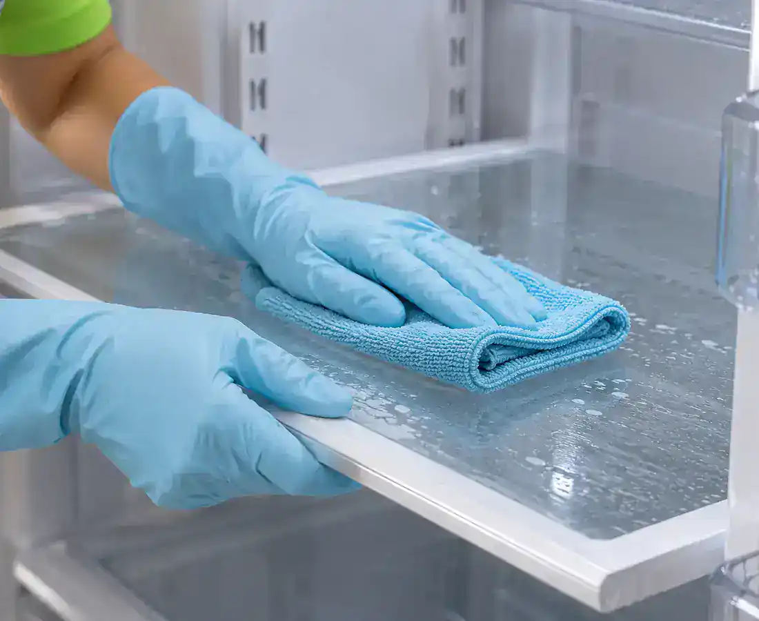 Manos con guantes limpiando cuidadosamente una superficie de cocina